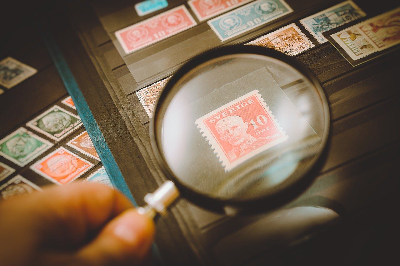 Appraiser evaluating a stamp with a magnifying glass